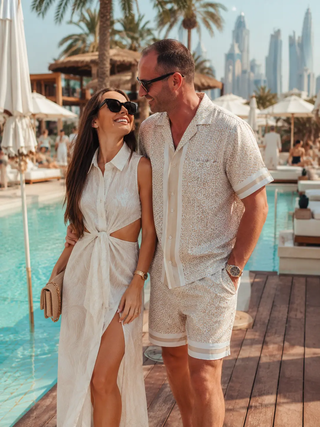 A couple in elegant resortwear at a Dubai beach club